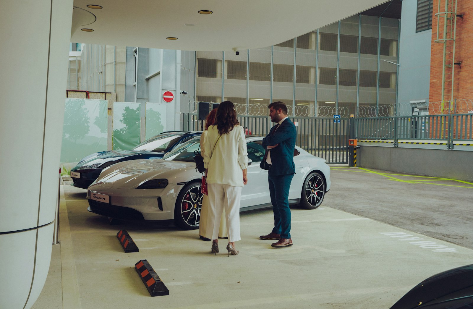 A couple of women standing next to a white car
