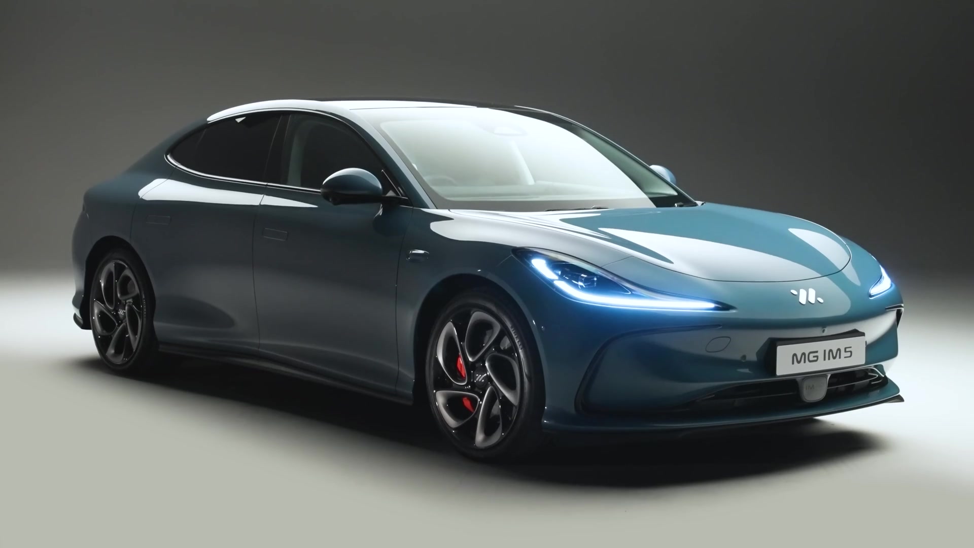 De MG IM5 elektrische sedan in een studio, schuin van voren