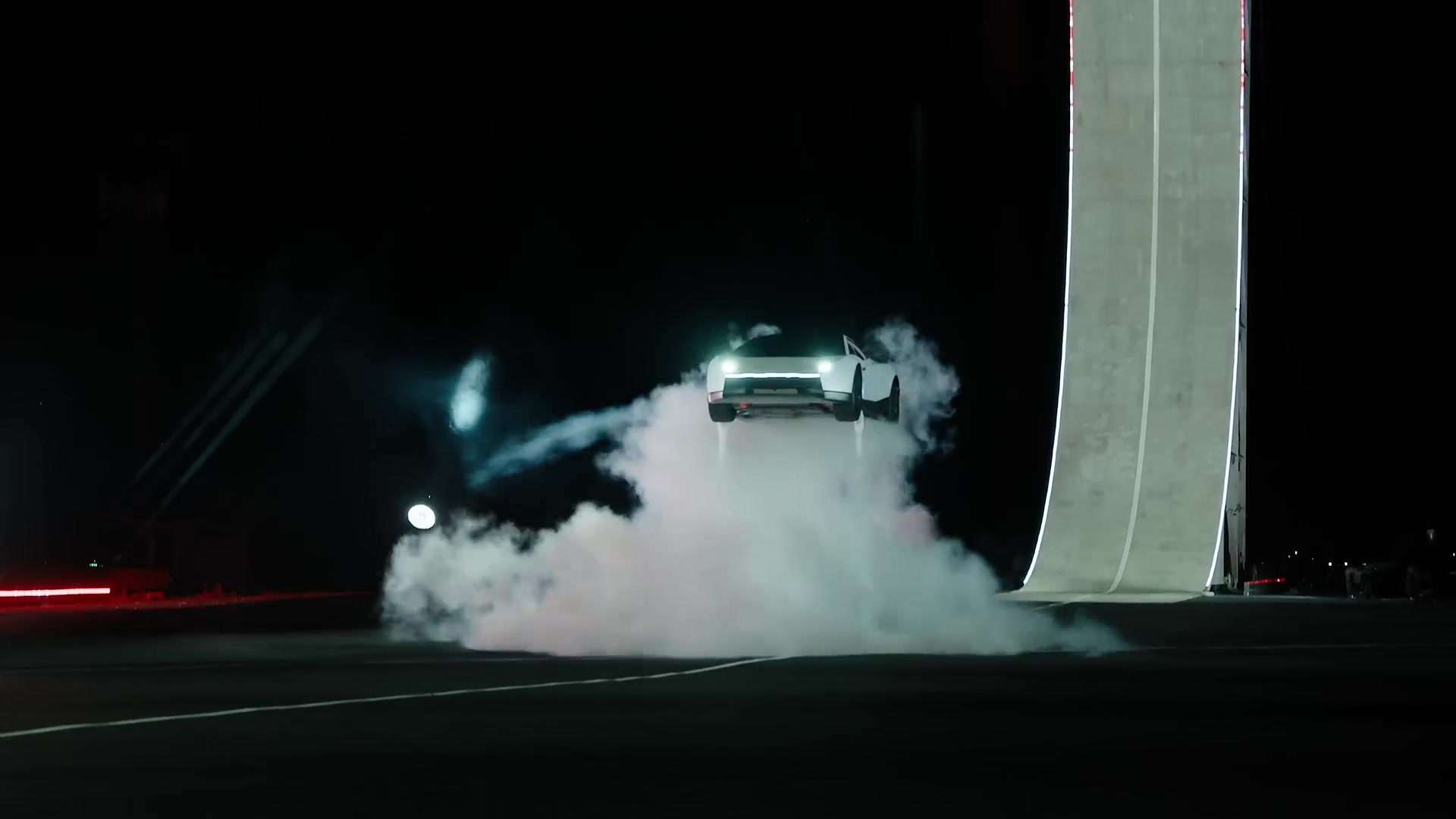 Witte nieuwe Tesla Roadster komt in een wolk rook aan na een sprong van een schans
